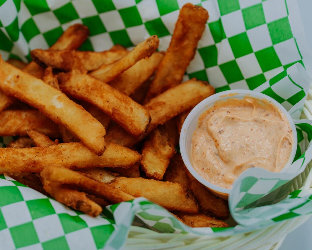 Koko's Deli seasoned fries with dipping sauce closeup